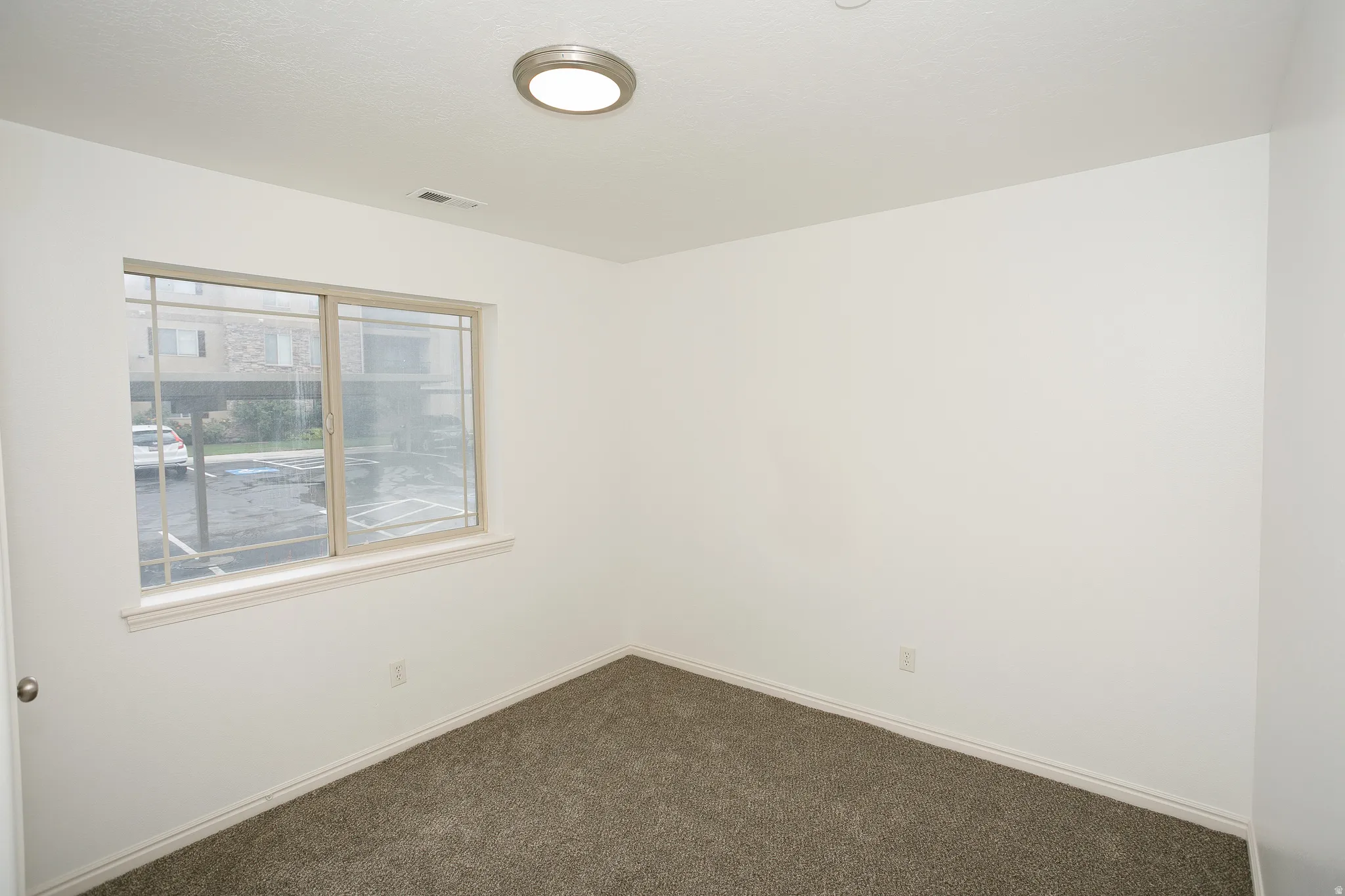 Room featuring light-colored walls and dark gray carpet