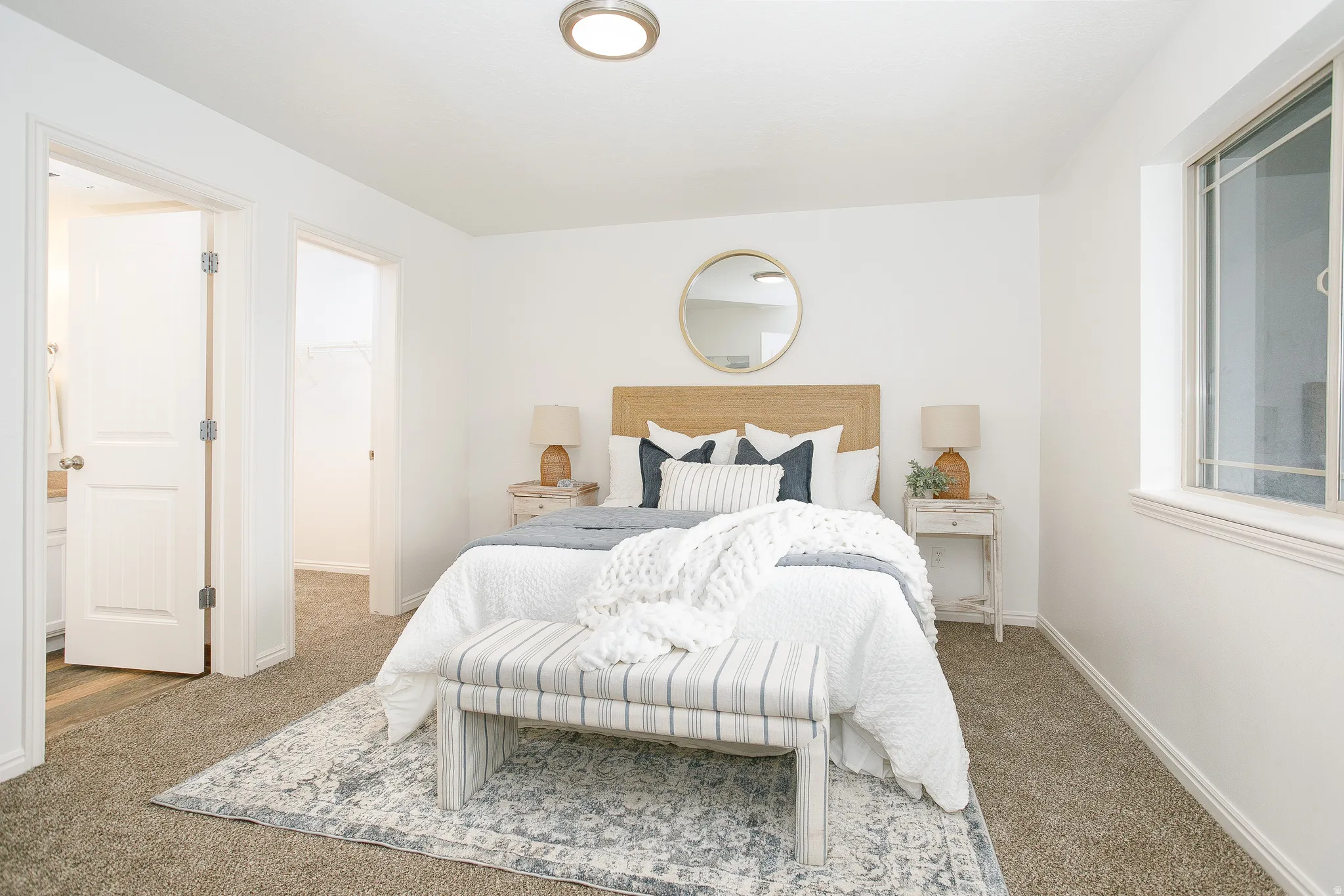 Carpeted room featuring a window, overhead flush mount light fixture, and two interior doors