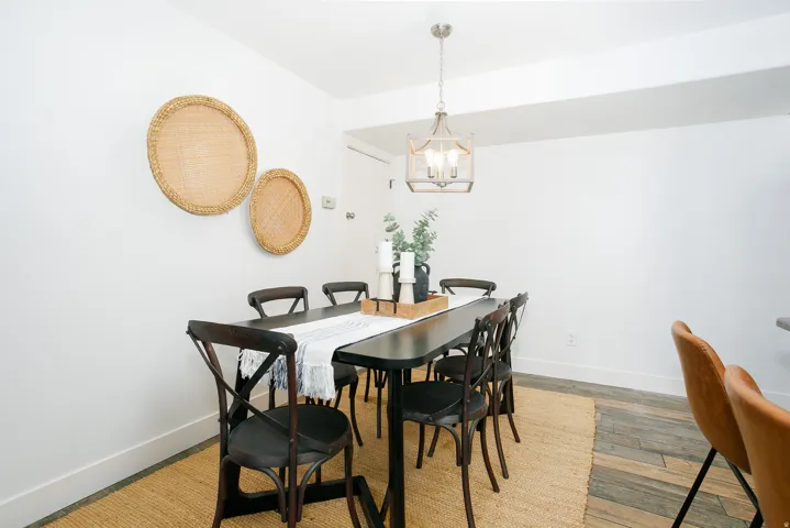 Dining area featuring white walls, a contemporary chandelier, and wood-finish flooring