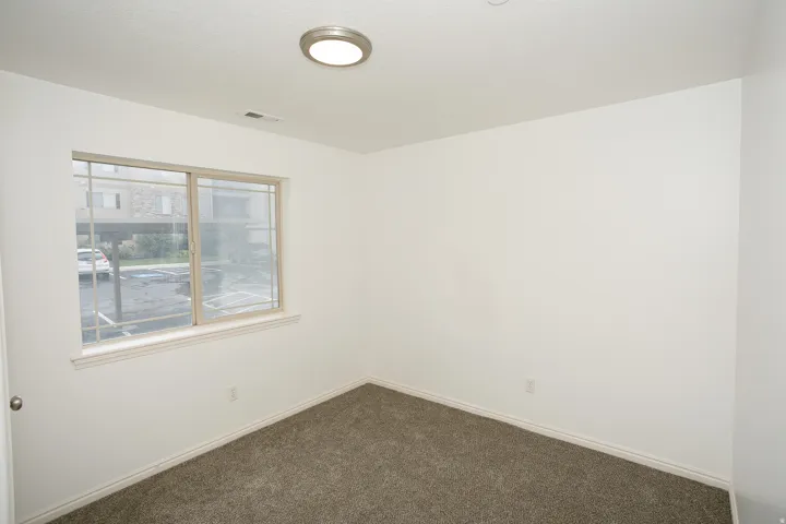 Room featuring light-colored walls and dark gray carpet
