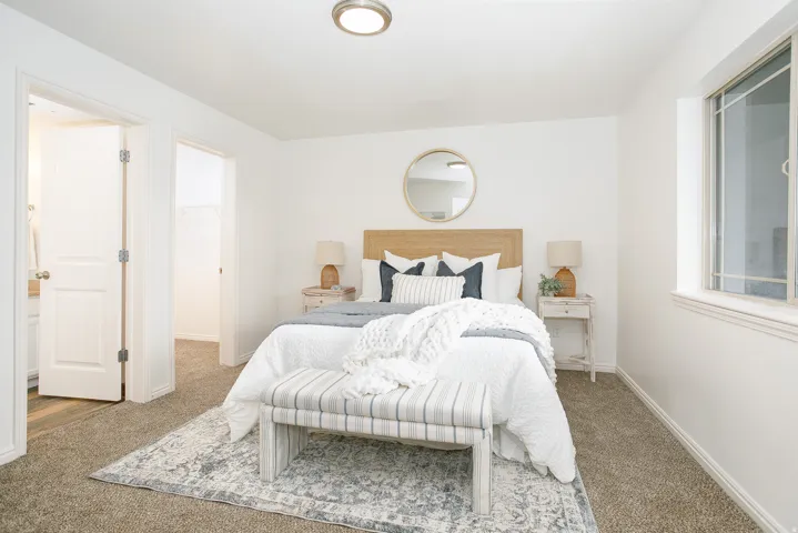 Carpeted room featuring a window, overhead flush mount light fixture, and two interior doors