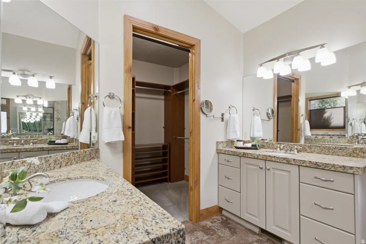 Luxurious master bathroom featuring dual vanities with granite countertops, soft-close cabinetry, and polished chrome fixtures