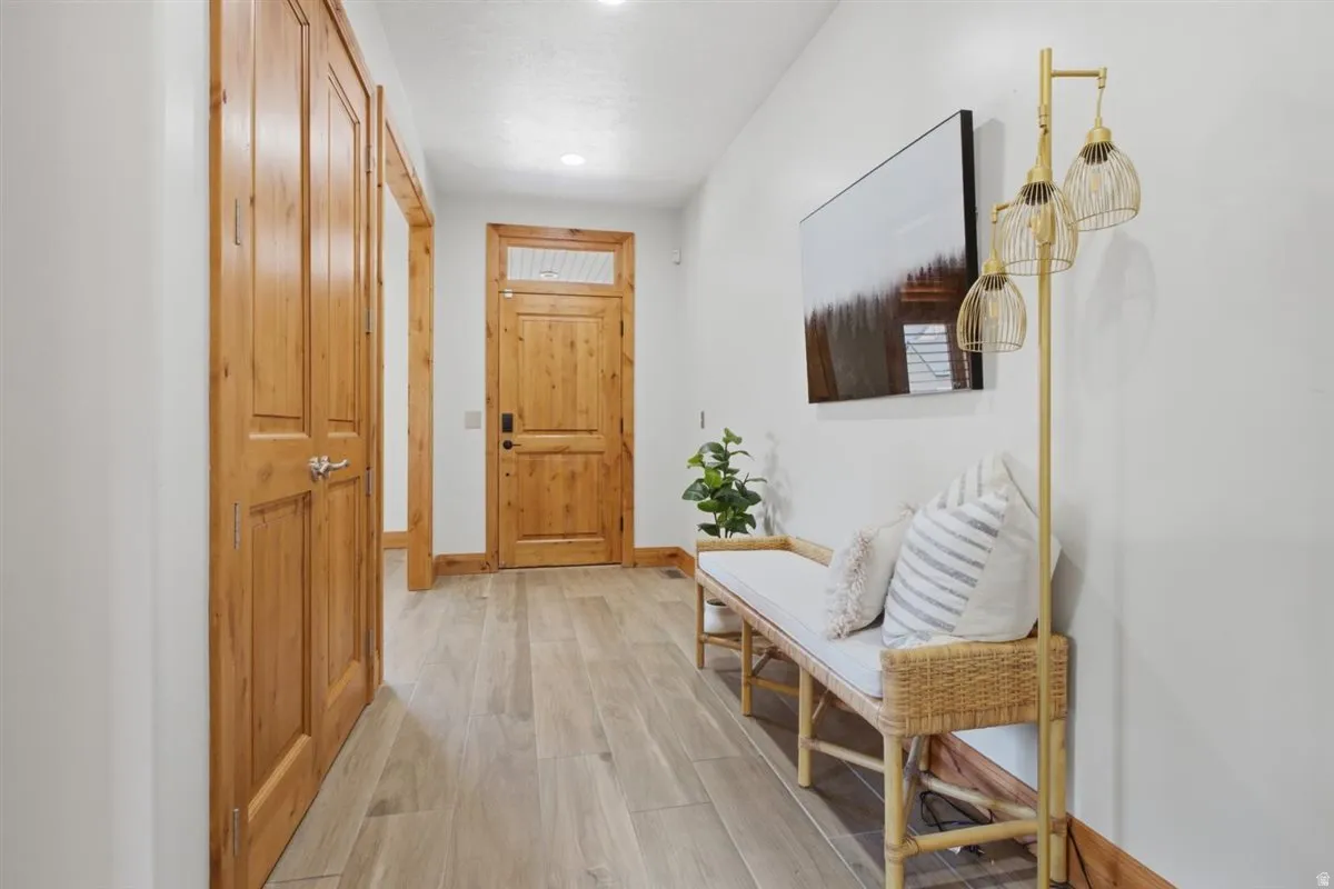 Entryway featuring natural wood doors and trim, light wood-finish flooring, and recessed ceiling lighting