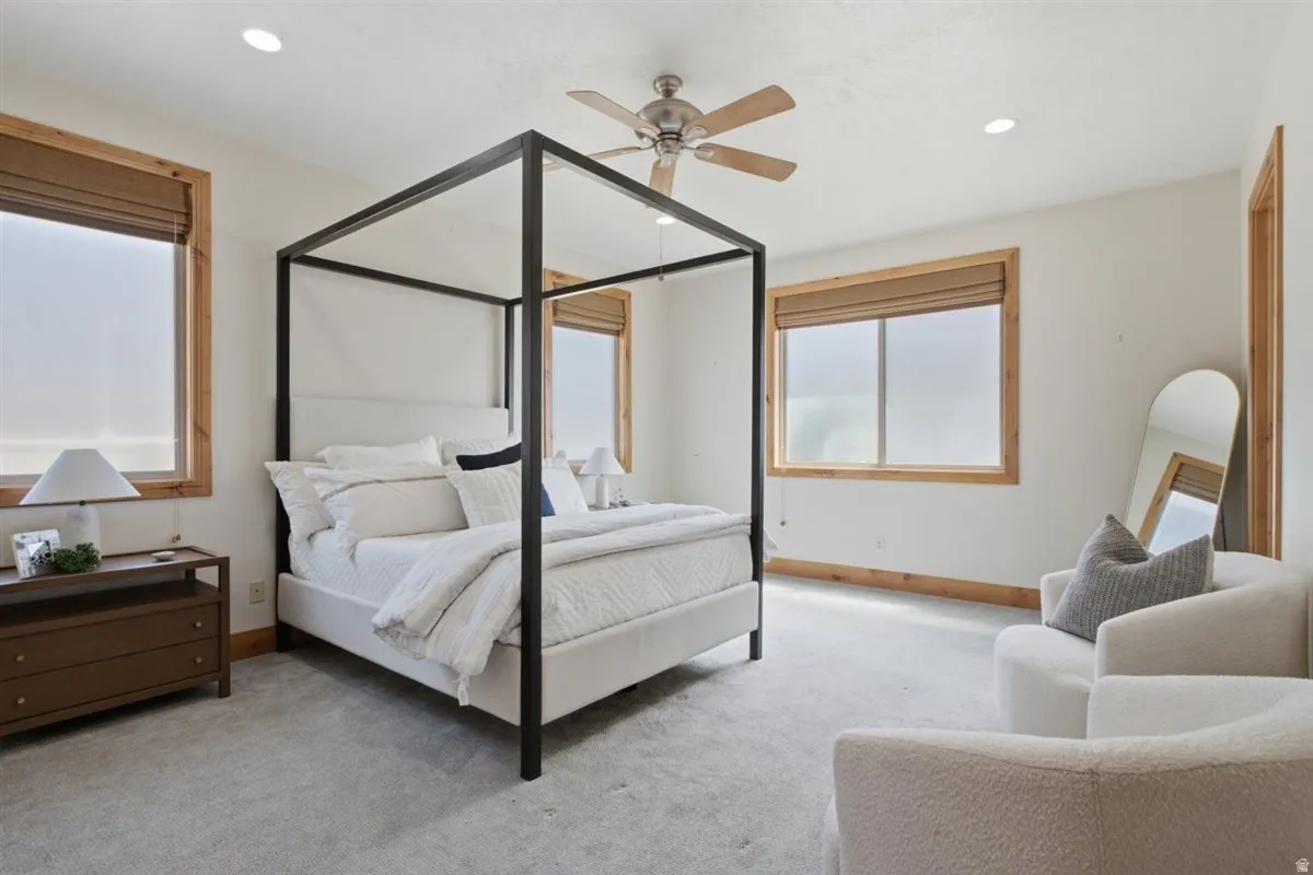 Spacious room featuring light-colored carpeting, recessed lighting, and a ceiling fan
