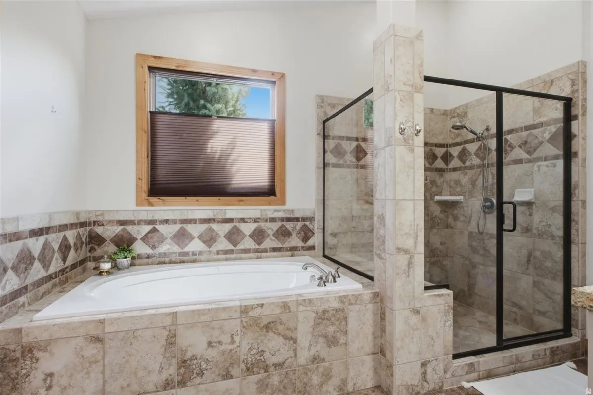 Built-in soaking tub with a tiled surround, featuring a diamond pattern accent border
