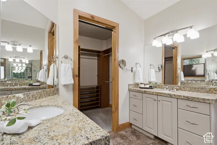 Luxurious primary bathroom featuring dual vanities with granite countertops, soft-close cabinetry, and polished chrome fixtures