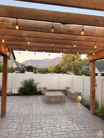 Paver patio featuring a built-in fire pit with stone surround and integrated seating