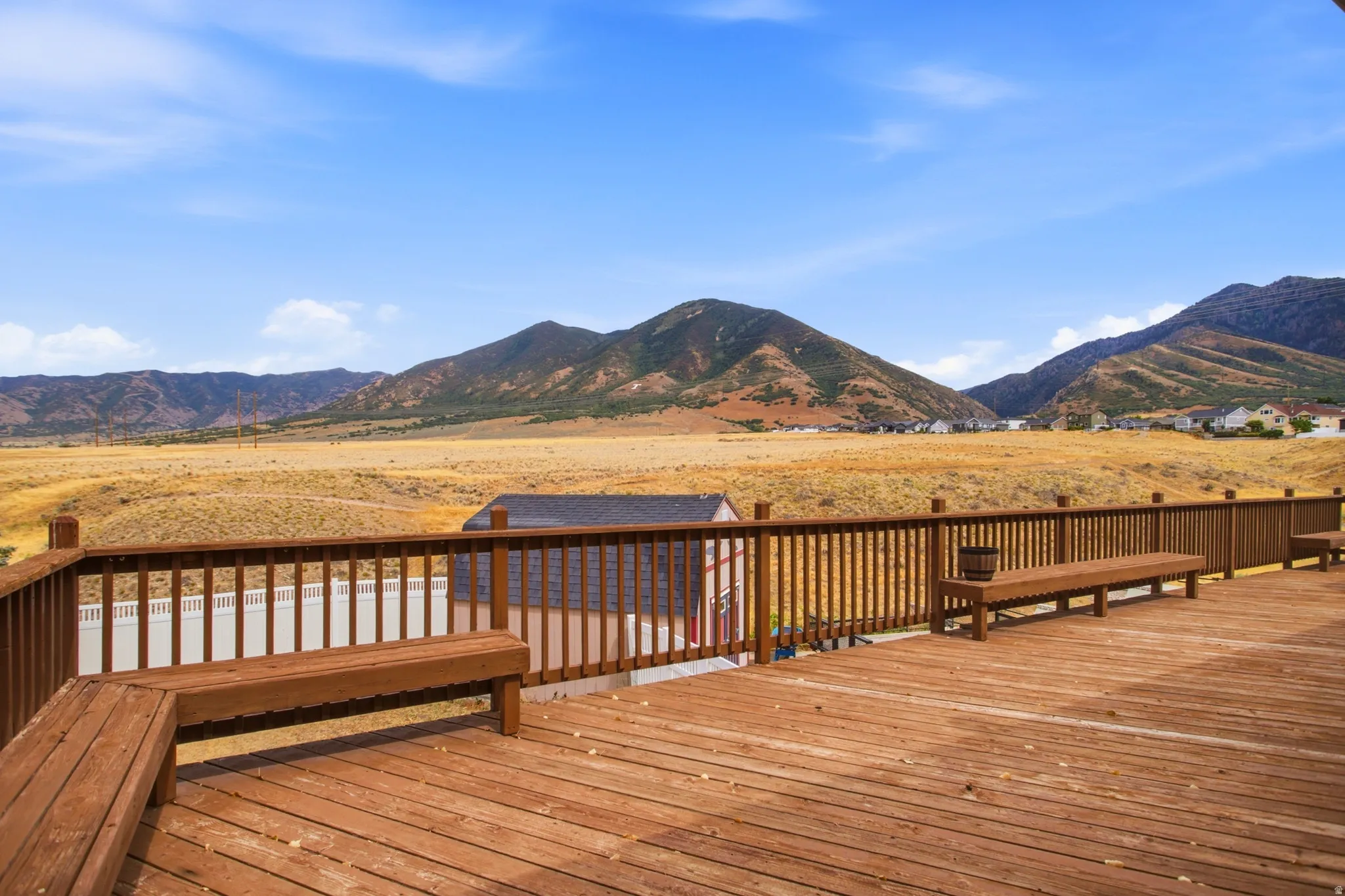 Expansive wood-finish deck with integrated seating and protective railing
