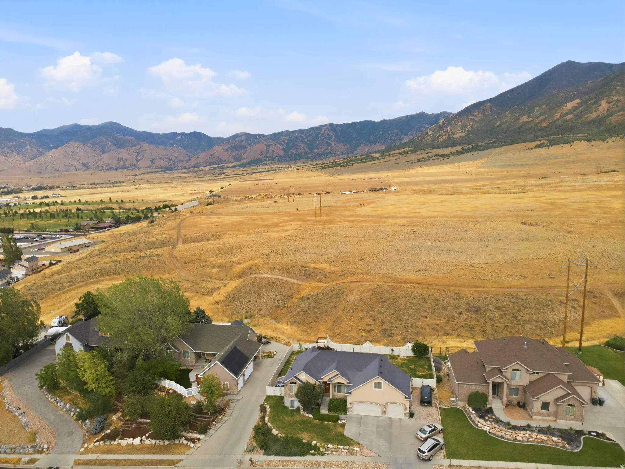 Residential property featuring a paved driveway, attached garage, and landscaped front yard