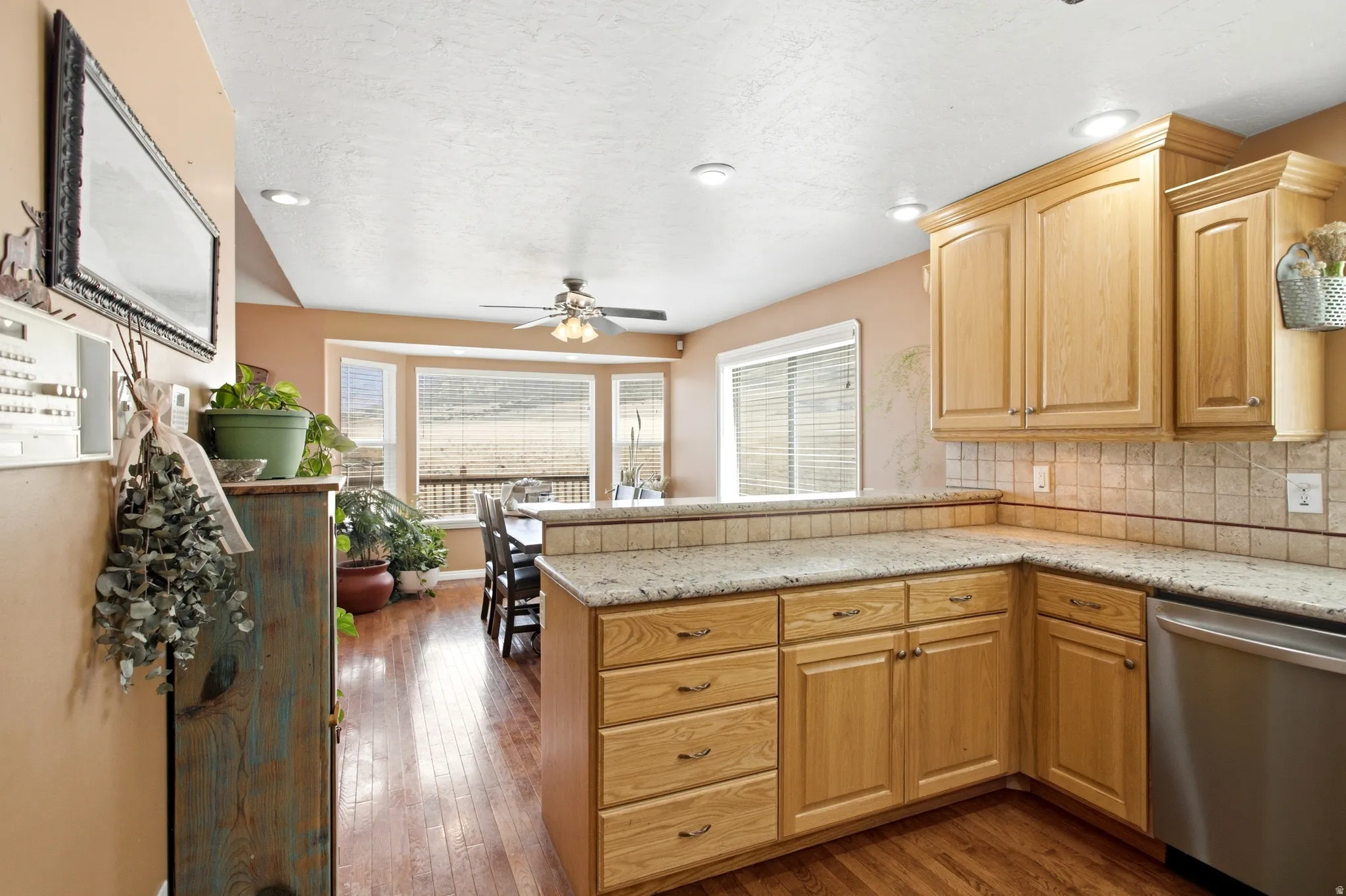 Kitchen featuring wood-finish cabinetry, light-toned countertops, and a tiled backsplash