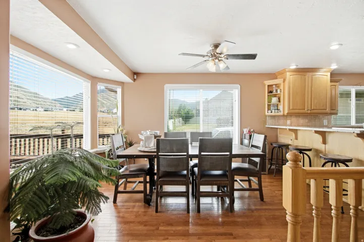 Open-concept dining area featuring wood-finish flooring, recessed lighting, and a ceiling fan