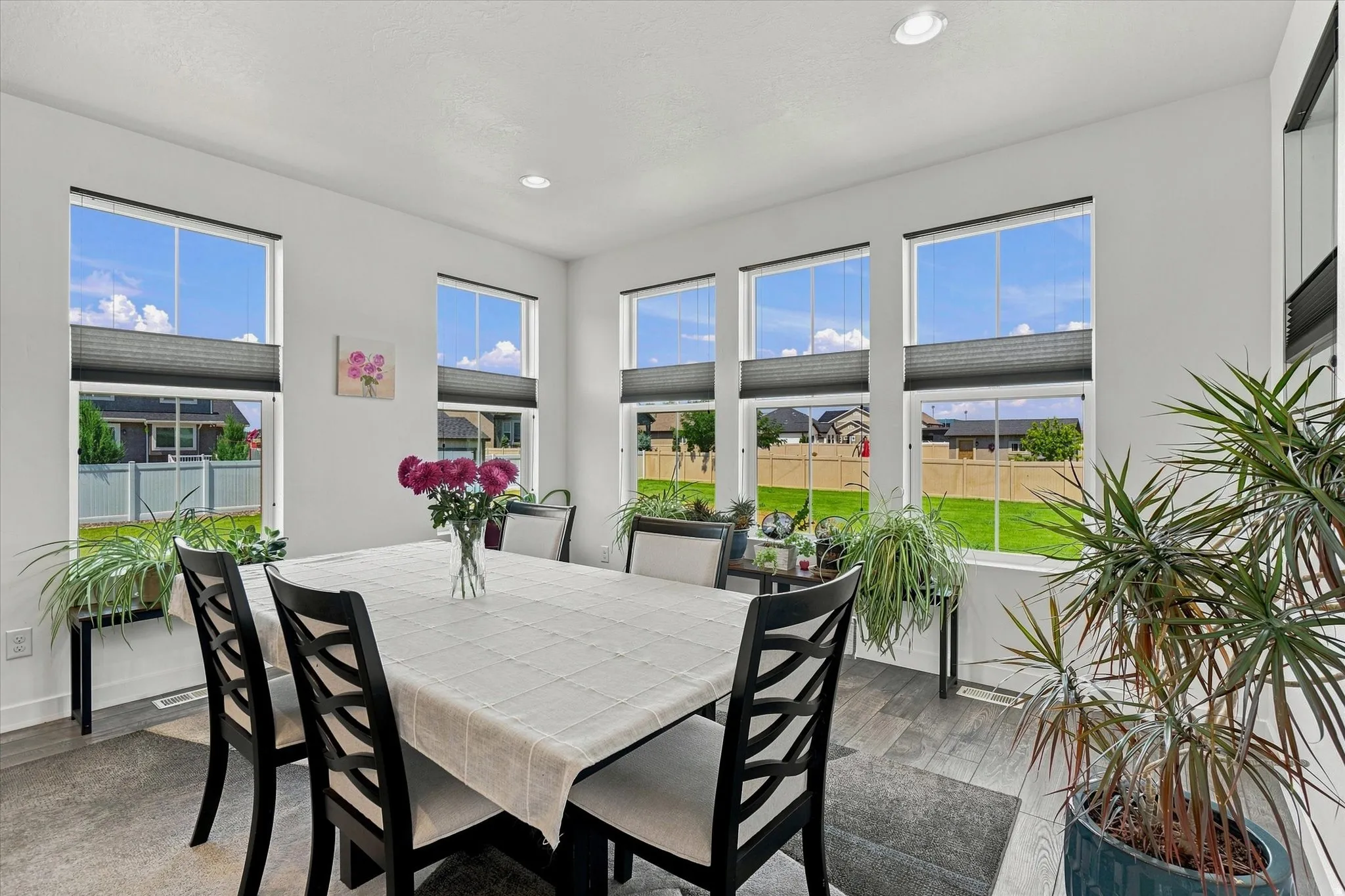 Dining area featuring abundant natural light from multiple windows with blinds, recessed lighting, and wood-finish flooring