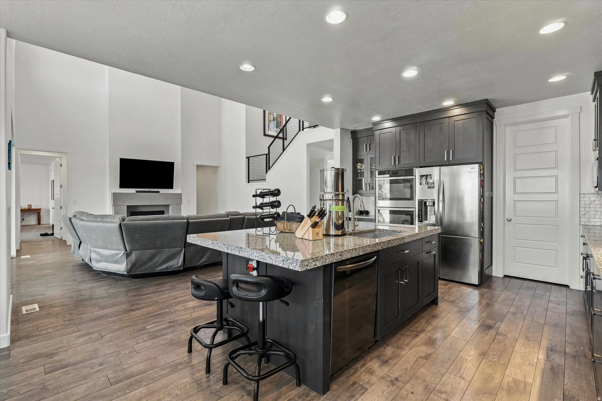 Kitchen island with granite countertop, dark wood-finish cabinetry, and stainless steel appliances
