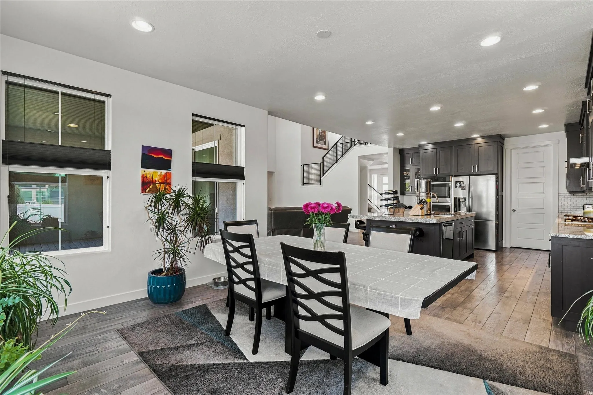 Open-concept living area featuring wood-finish flooring, recessed lighting, and a kitchen island with seating