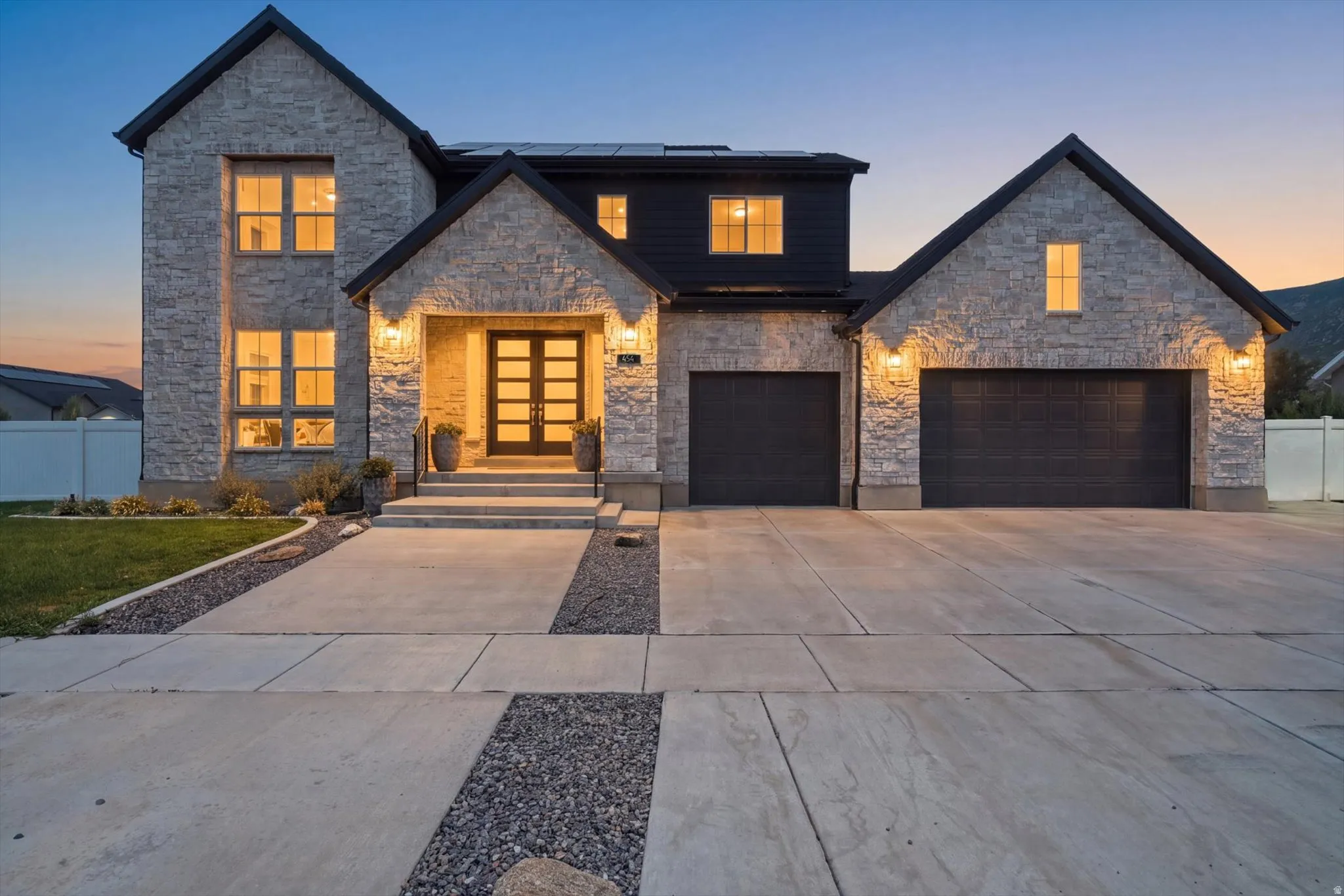 Stone veneer exterior with dark contrasting siding and gabled rooflines