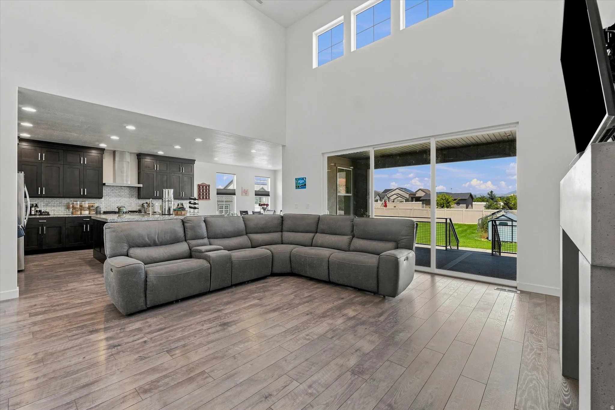 Open-concept living area with soaring ceilings and wood-finish flooring