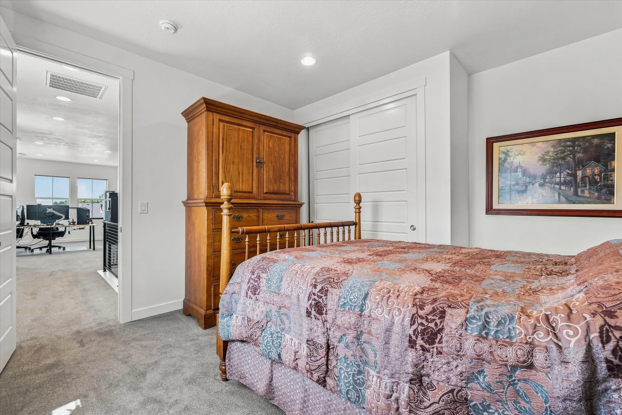 Carpeted bedroom featuring white walls, recessed lighting, and a white sliding closet door
