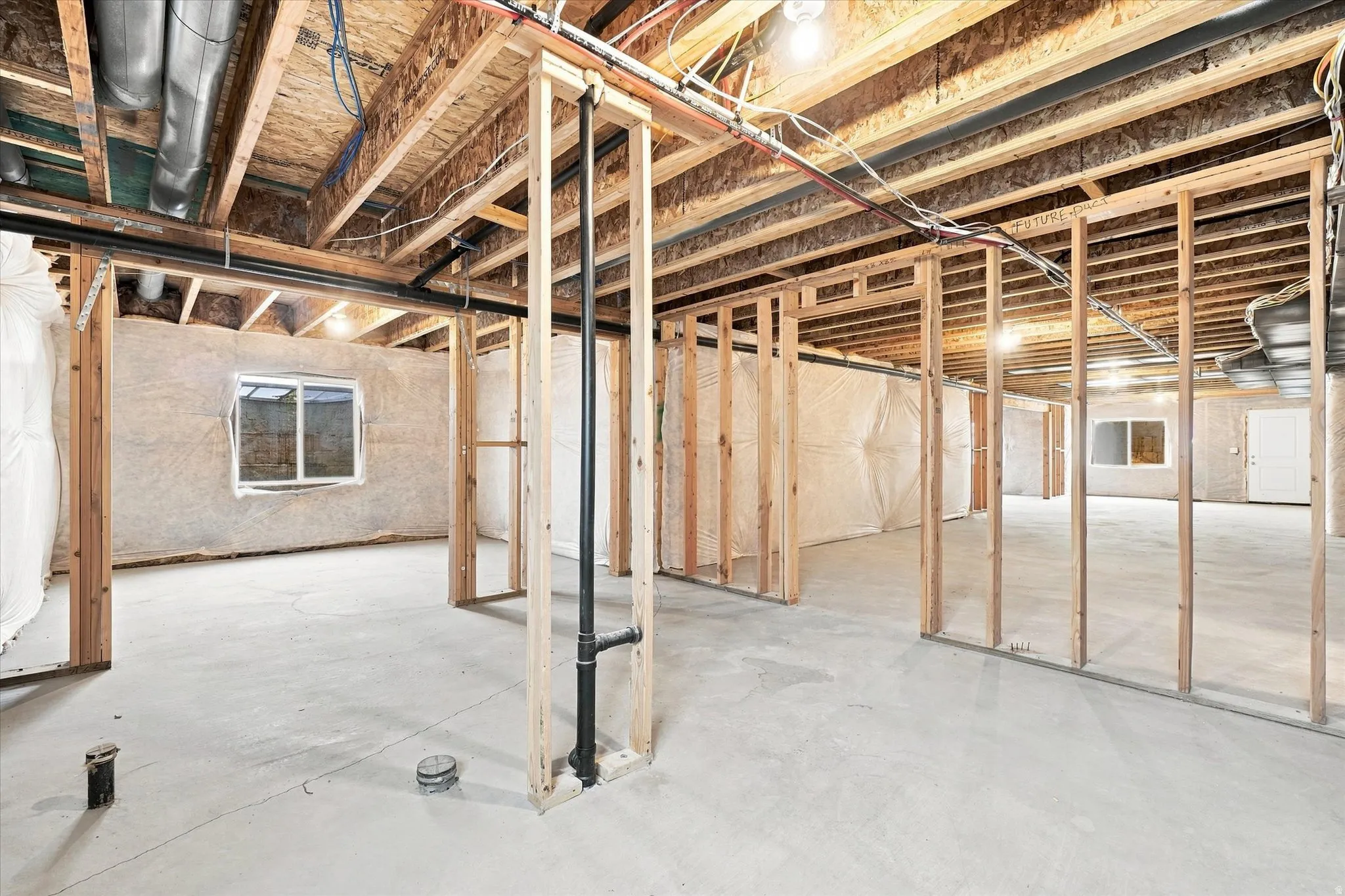 Unfinished basement featuring wood framing and concrete flooring