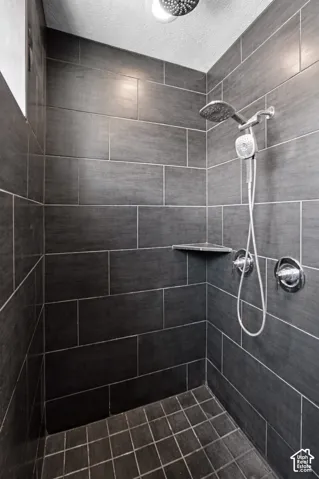 Primary Bathroom with Tiled shower with handheld shower fixture and built-in corner shelf