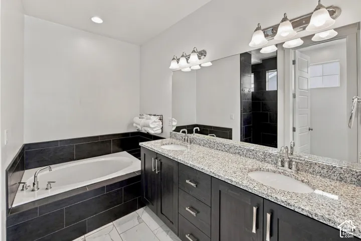 Dual vanity with granite countertop, undermount sinks, and dark wood-finish cabinetry