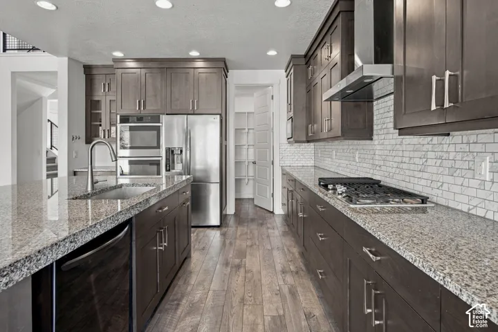 Engineered wood flooring throughout the kitchen with recessed lighting