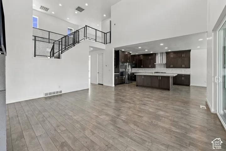 Open-concept living great room with engineered wood flooring. View comming from primary bedroom.