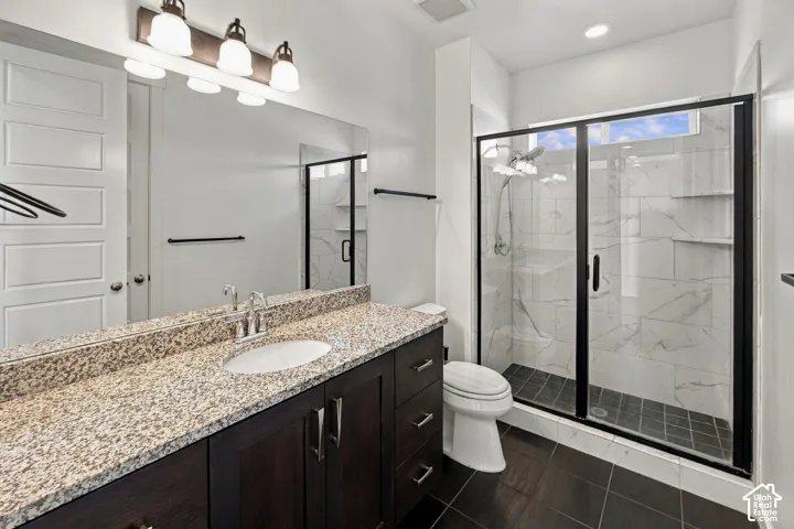 Dark wood-finish vanity with a granite countertop, undermount sink, and chrome faucet