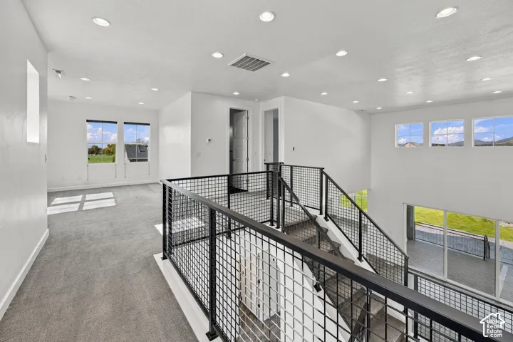 Open-concept landing viewing loft area with an abundance of south facing windows and recessed lighting