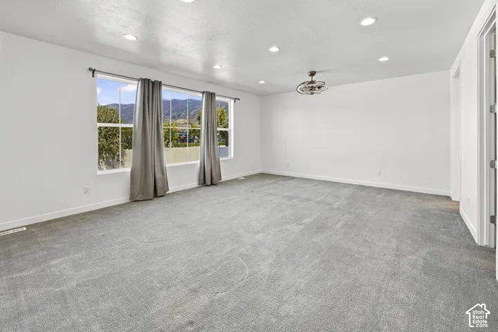 Expansive Primary Bedroom tucked away from the noises of the family, with recessed lighting, and a decorative ceiling fixture