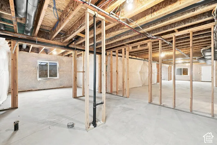 Unfinished basement featuring wood framing and concrete flooring