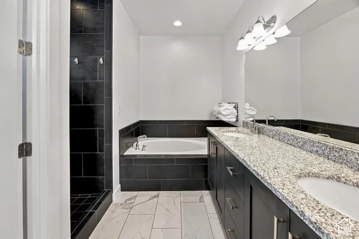 Primary BedrppmDual vanity with granite countertop, undermount sinks, and chrome faucets
