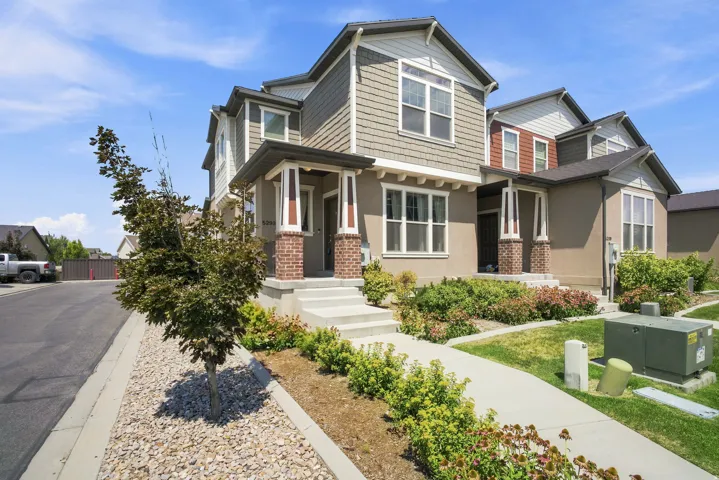 Multi-story property featuring a prominent portico entry with brick columns