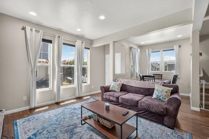 Living area featuring wood-finish flooring, recessed lighting, and multiple windows
