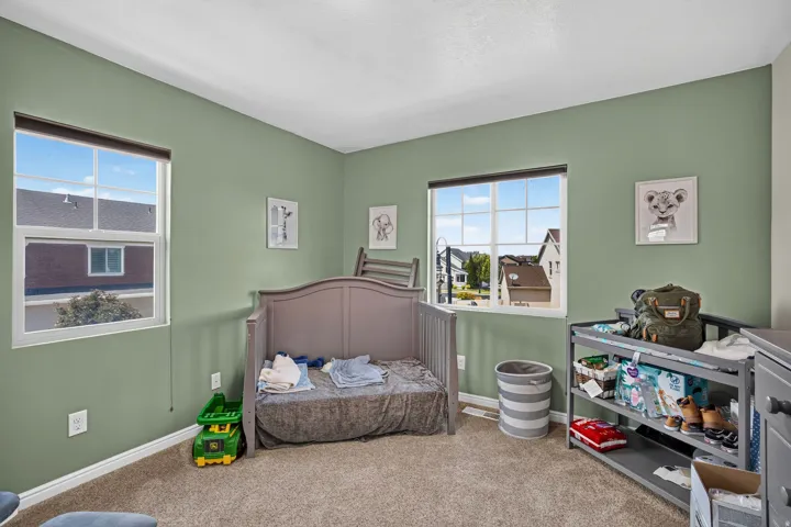 Carpeted room with sage green walls and white trim
