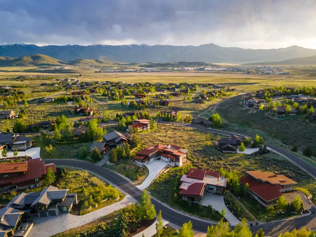 Expansive property featuring multiple residences, paved driveways, and mature landscaping