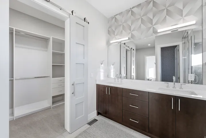 Double vanity with integrated sinks, quartz countertop, and dark wood-finish cabinetry