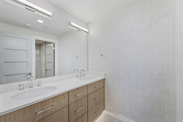 Dual vanity with integrated sinks, wood-finish cabinetry, and polished chrome hardware