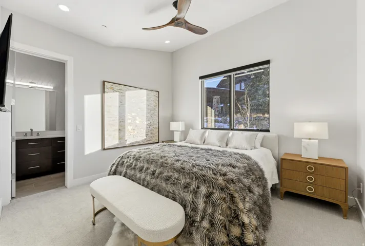 Spacious bedroom featuring light neutral walls, recessed lighting, and a modern ceiling fan