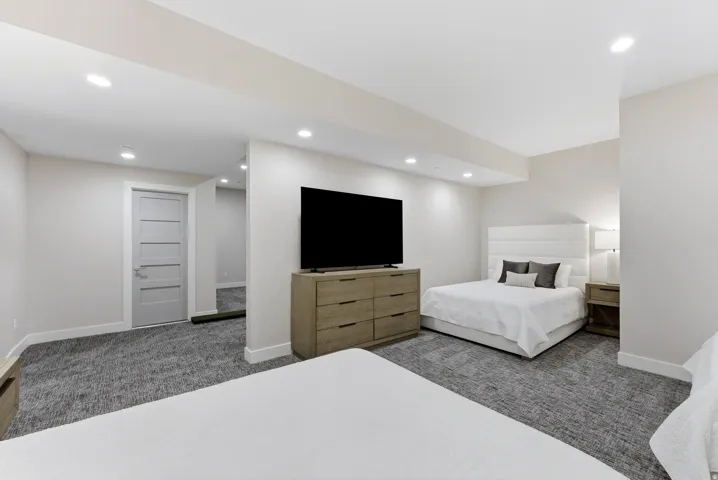 Carpeted room with recessed lighting, light gray walls, a modern five-panel interior door, and white baseboards
