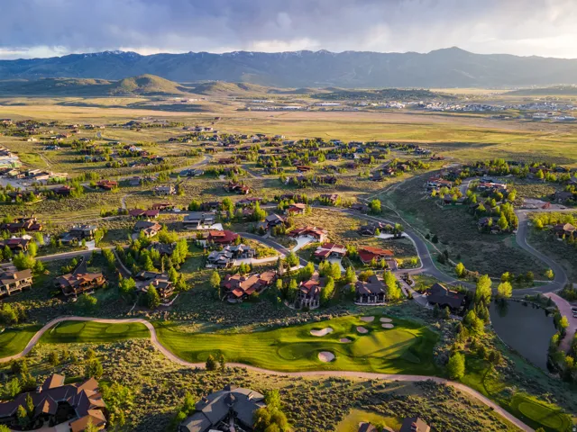 Expansive mountain community featuring custom homes, winding roads, a golf course, and a natural pond
