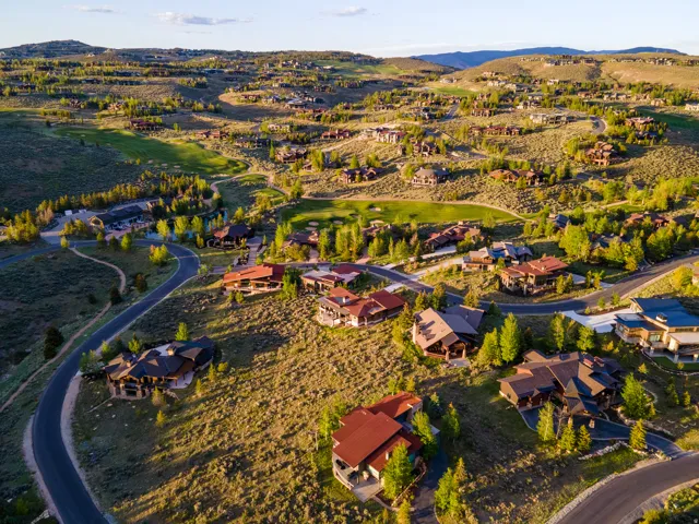 Expansive hillside community featuring numerous custom homes, paved roads, and mature trees