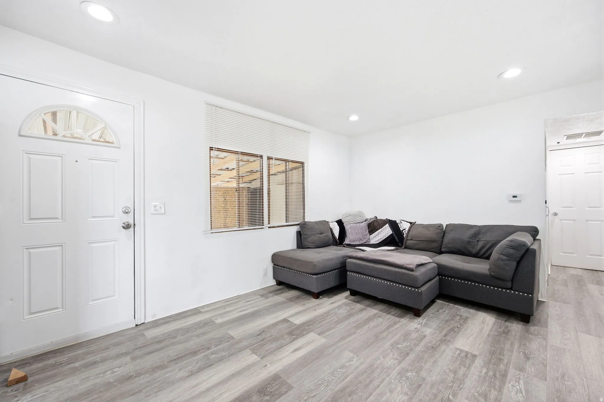 Bright interior space featuring light wood-finish flooring, white walls, and recessed lighting
