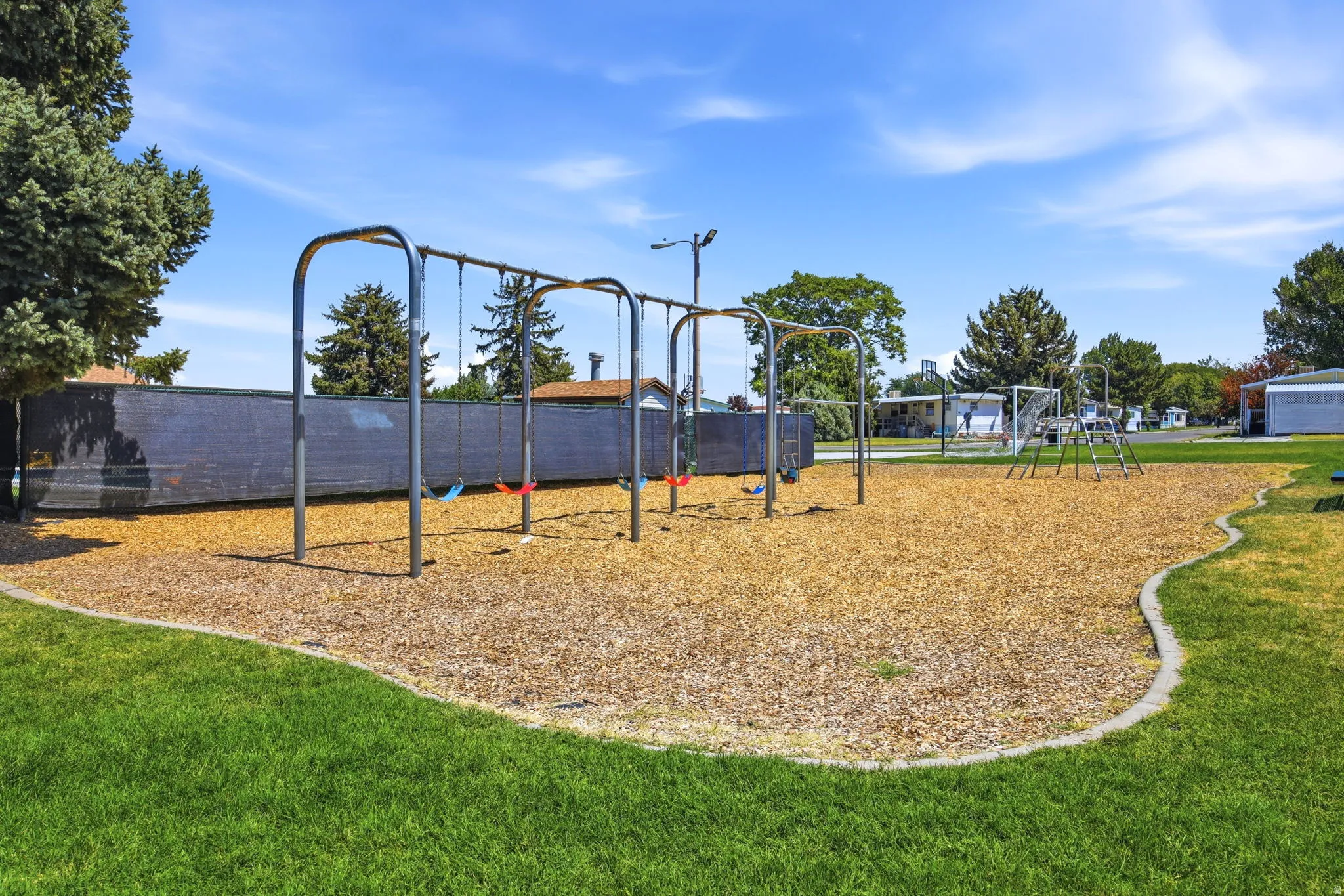Well-maintained community playground featuring multiple monkey bars and overhead structures set within a spacious recreational area
