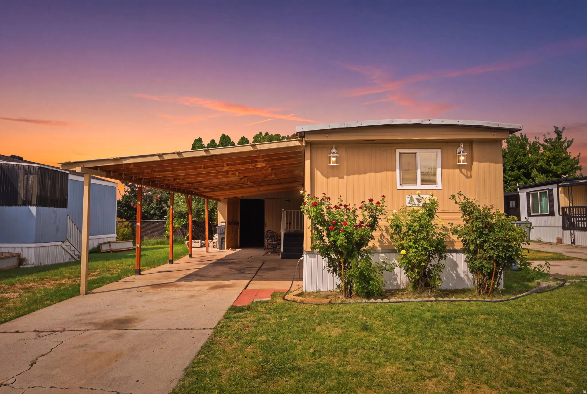 Exterior featuring tan siding, a covered carport, and a concrete driveway