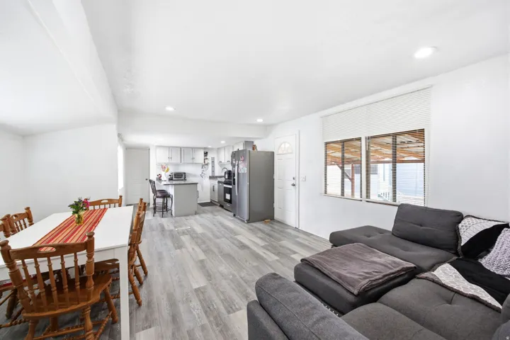 Open-concept living space featuring wood-finish flooring, recessed lighting, and a kitchen with light-toned cabinetry