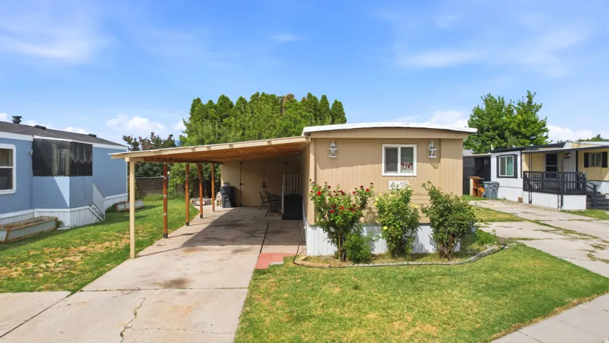 Single-story residence featuring light-colored siding and a covered carport