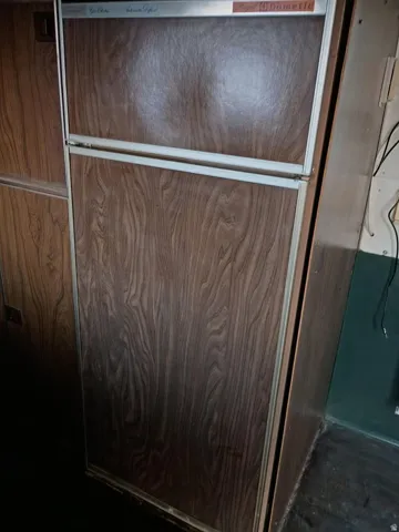 Integrated wood-finish panel refrigerator and freezer unit featuring a brushed metal trim