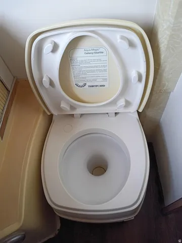 Aqua-Magic Galaxy/Starlite toilet with a white basin and a beige lid