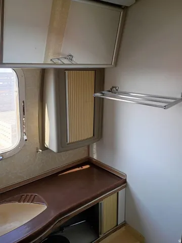 Compact vanity area featuring an integrated sink, brown countertop, and corrugated cabinet fronts