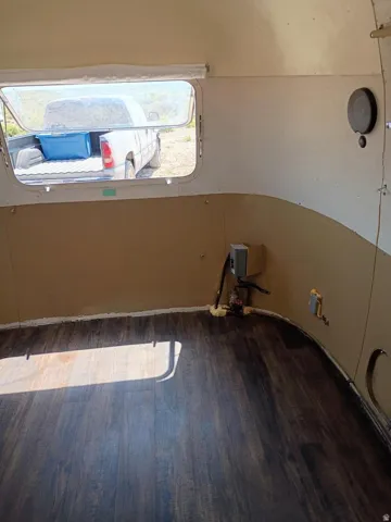 Interior space featuring wood-finish flooring, a rectangular window, and curved wall paneling